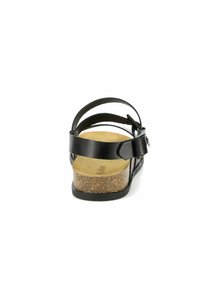 Sandalias de cuero negro con múltiples correas, suela de corcho en cuña y plantilla texturizada. Presenta una hebilla lateral para un ajuste ajustable.
