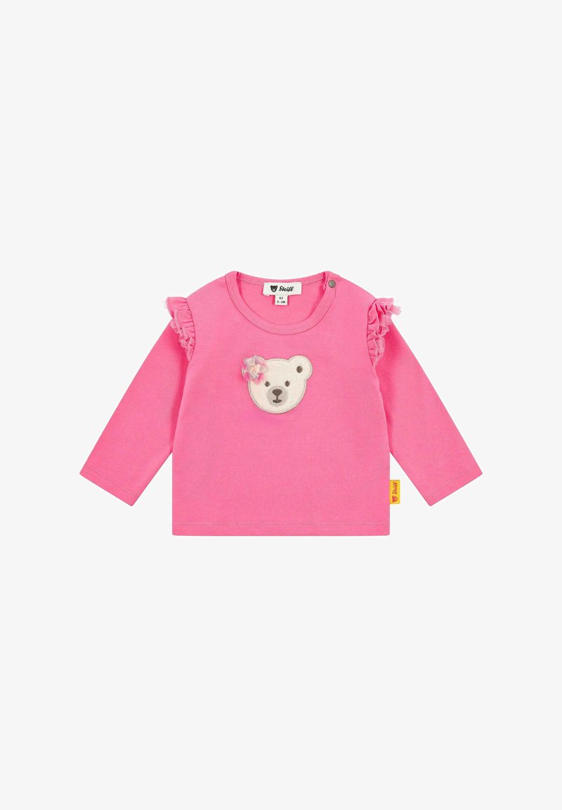 Rosa Langarmshirt mit einem Bärenkopf-Applikation in der Mitte und Rüschendetails an den Ärmeln. Hergestellt aus weichem Baumwollstoff.