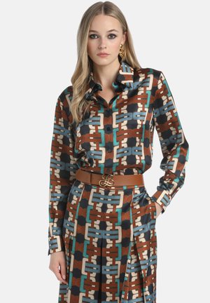 Kuviollinen paita, jossa on ruskea, teal ja kerma beige geometrinen muotoilu, pitkät hihat, nappikiinnitys ja ruskea vyö logokoristeella.