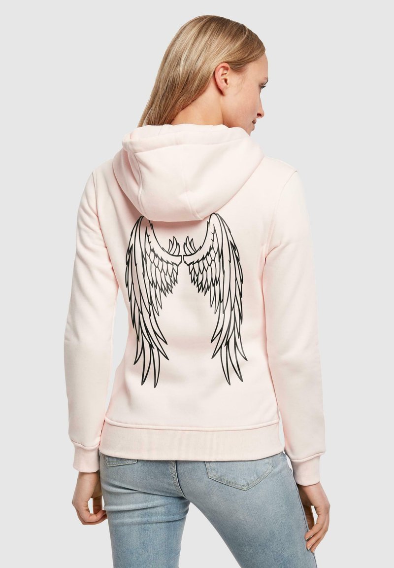 Felpa rosa con un design aderente, dotata di una grafica nera di ali sul retro. I polsini e l'orlo a coste conferiscono struttura. Materiale in morbido cotone misto.