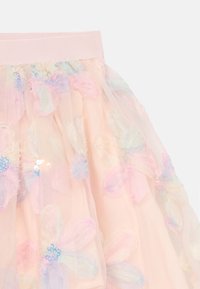 Tulle skirt in soft pink with floral appliqués in pastel colors. Features sequins and a wide pink elastic waistband.