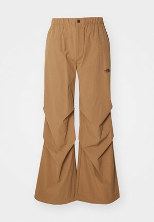 Pantaloni maro, cu croi larg, având un talie elastică și închidere cu nasture. Caracterizează un design din țesături stratificate și un logo mic pe lateral.