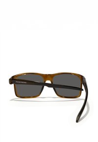 Pruunid ja mustad ristkülikukujulised päikeseprillid hallide läätsedega. Õhukesed sangad, millel on "HAWKERS" logo. Sile plastraam, kerge disain.