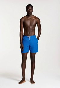 Siniset uimaletkut, joissa on nyörivö, valmistettu kevyestä kankaasta, sileä pinta ja minimalistinen muotoilu.