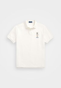 Vit pikétröja i bomull med en treknappslå, korta ärmar och en broderad polo-spelare logotyp på vänster bröst.