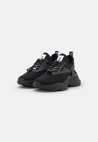 Black athletic shoes featuring a mesh upper, rubber sole, rounded toe, and lace-up design with contrasting white accents.