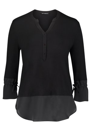 Zwarte blouse met lange mouwen, drie knopen bij de V-hals, geplooide manchetten met strikjes en een halfdoorzichtige stofpaneel aan de zoom.