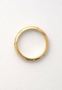 Goldring mit abgerundeten Kanten, der kleine dekorative Steine in einem wellenförmigen Design eingebettet hat. Glatte, glänzende Oberfläche; keine scharfen Details.