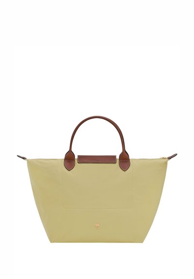 Light yellow nylon bag with brown leather handles and accents. Features a flat design, zip closure, and a front pocket.