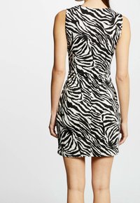 Kurzärmliges Kleid mit schwarzem und weißem Zebramuster, taillierte Silhouette, glatter Stoff, knielang, mit rundem Ausschnitt und hinterer Nahtdetail.