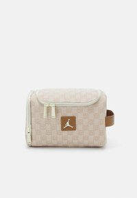 Braune und beige Kosmetiktasche mit einem gesteppten Muster, einem oberen Reißverschluss und einem Logopatch auf der Vorderseite. Strukturierte Stoffoberfläche.