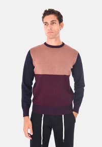 Maglione a blocchi di colore in bordeaux, marrone e blu navy. Materiale lavorato a maglia, colletto rotondo e polsini a coste. Taglio dritto con una texture liscia.