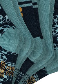 Calze multicolori con una base turchese e motivi blu navy e senape. La texture è liscia, con dettagli a coste lungo i polsini.