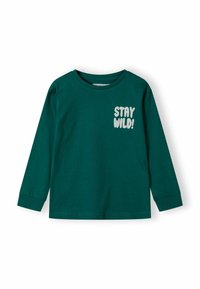 Tumši zaļš kokvilnas T-krekls ar garām piedurknēm, kurā uz kreisās krūts vietas ir uzraksts "STAY WILD!" baltā krāsā. Ērta piegriezne ar ribotas piedurknes.