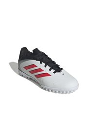 Botas de fútbol Adidas en blanco con acentos negros y franjas rojas. Presentan una parte superior suave, costuras pronunciadas y una suela externa de goma moldeada.