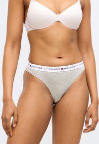 Bikini in cotone grigio con elastico bianco in vita con il logo "TOMMY HILFIGER". Texture liscia, design a vita bassa.