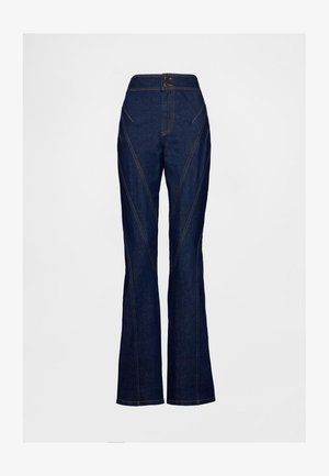 Tamsiai mėlyni džinsai platėjančiomis kojomis, aukštu liemeniu, kampuotomis siūlėmis ir toniniu siuvimu. Du mygtukai liemens srityje pabrėžia dizainą.