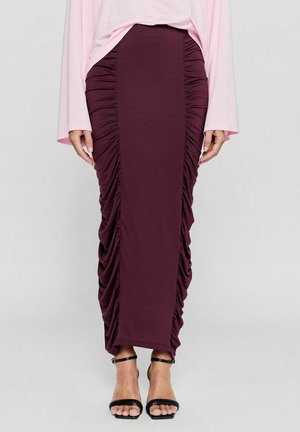 Bordeaux midi-jurk gemaakt van zachte stof met verticale plooidetails en een aansluitende silhouet. Gekocht met zwarte sandalen met bandjes.
