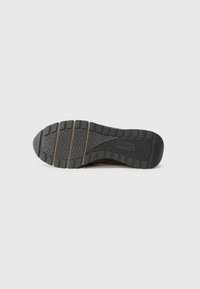 Brown leather shoe sole with deep tread, multiple grooves, and reinforced accents; features a smooth finish with durable rubber material.