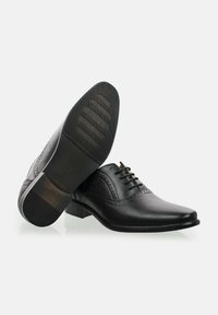 Zapatos de vestir de cuero negro con un acabado liso, punta afilada y perforaciones decorativas. Cuentan con una suela de goma texturizada para mayor agarre.