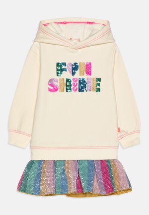 Robe en hoodie crème avec "FUN SHINE" en sequins multicolores. Présente une jupe à volants rayée brillante dans des teintes de bleu, rose et or.