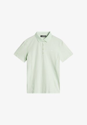 Lichtgroene polo gemaakt van textured stof, met een subtiel golfpatroon, drie-knopen sluiting en een klein logo op de borst.