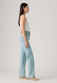 Lichtblauwe high-waisted jeans met een losse pasvorm en rechte benen. Voorzien van een gelabelde leren patch en stiksels op de achterkant.