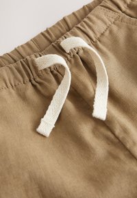 Brauner Stoffbund mit weißen Kordeln. Glatte Textur mit gerafftem Design und zwei Stoffschlaufen nahe der Mitte. Minimalistischer Stil.