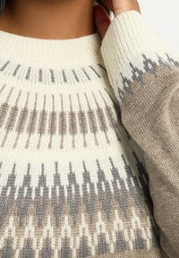 Maglione lavorato a maglia con collo rotondo, caratterizzato da una base color crema e motivi geometrici in tonalità marrone e grigia, tessuto texturizzato.