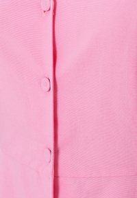 Camicia button-up rosa con una texture liscia, dotata di sei bottoni in tessuto abbinato lungo la parte frontale e un design pulito e sartoriale.