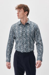 Langärmliges Hemd in Blau und Weiß mit komplexem Paisleymuster. Aus Baumwolle gefertigt, mit Kentkragen und schmaler Passform.