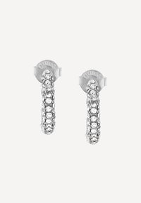 Boucles d'oreilles en argent en forme de créoles avec une surface texturée et des pierres précieuses transparentes dispersées, fermées par un fermoir à enclenchement.