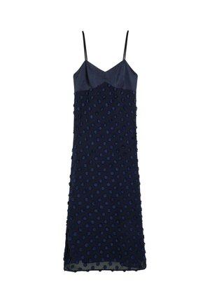 Vestido azul marino con tirantes finos, que presenta un diseño de lunares texturizados y un cuerpo liso. El dobladillo tiene una pequeña abertura para facilitar el movimiento.