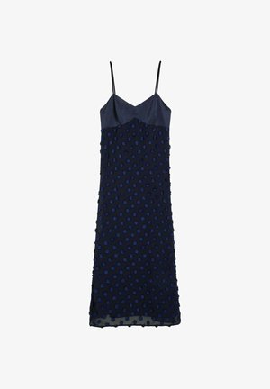 Diepblauwe jurk met dunne bandjes, voorzien van een textuur met stippen en een gladde lijf. De zoom heeft een lichte split voor beweging.