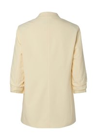 Veste de couleur crème avec manches trois-quarts vue de dos, montrant un design épuré et simple sans décorations visibles.