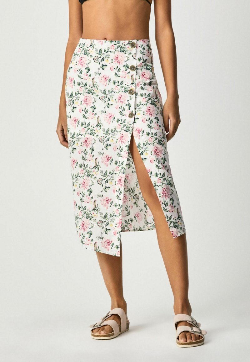 Jupe midi blanche à fleurs, ornée de fleurs roses et de feuilles vertes, avec une fente sur le côté et des accents de boutons sur le côté gauche. Le tissu est léger.
