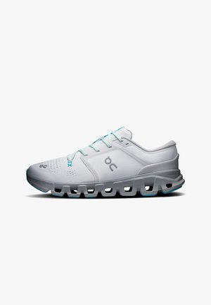 Chaussure de course gris clair avec lacets turquoise et semelle amortissante composée de segments rectangulaires creux, logo latéral et empeigne en mesh respirant.