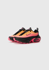 Nike Air tenisice s bojom gradijenta od narančaste do ružičaste, crnim akcentima, teksturiranom tkaninom i vidljivim zračnim jastucom u potplatu.