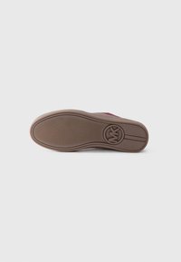 Brown rubber shoe sole with textured pattern; circular logo at heel. Flat design with reinforced edges for durability.