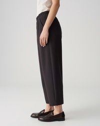 Black, elastic-waist trousers with a straight leg design, featuring side pockets and a smooth texture. Paired with dark loafers.
