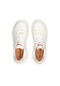 Zapatillas de piel blanca con diseño perforado, acentos beige contrastantes y cordones blancos. Presenta una plantilla de marca y una textura suave.