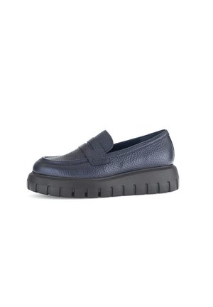 Navy leather slip-on shoe with a textured finish, thick black sole, and a rounded toe. Features a discreet strap across the top.