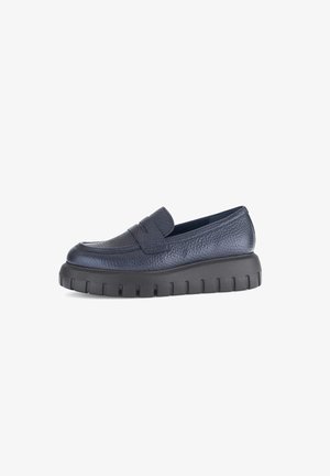 Navy leather slip-on shoe with a textured finish, thick black sole, and a rounded toe. Features a discreet strap across the top.