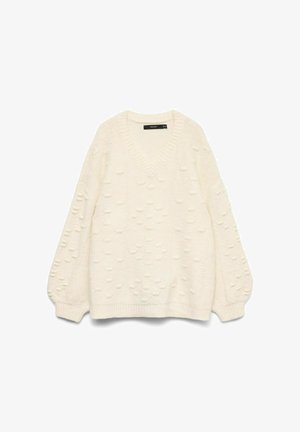 Cream-colored knitted sweater with V-neck, textured raised dot pattern, long balloon sleeves, and ribbed cuffs and hem.