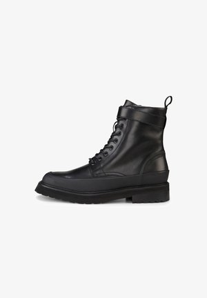 Stivali ankle in pelle nera con finitura liscia, punta rotonda, suola piatta e design con lacci; dotati di un dettaglio laterale e supporto rinforzato alla caviglia.