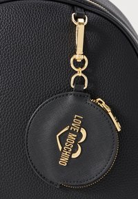 Black leather textured bag with attached round black coin pouch, gold zipper, and "LOVE MOSCHINO" gold logo.