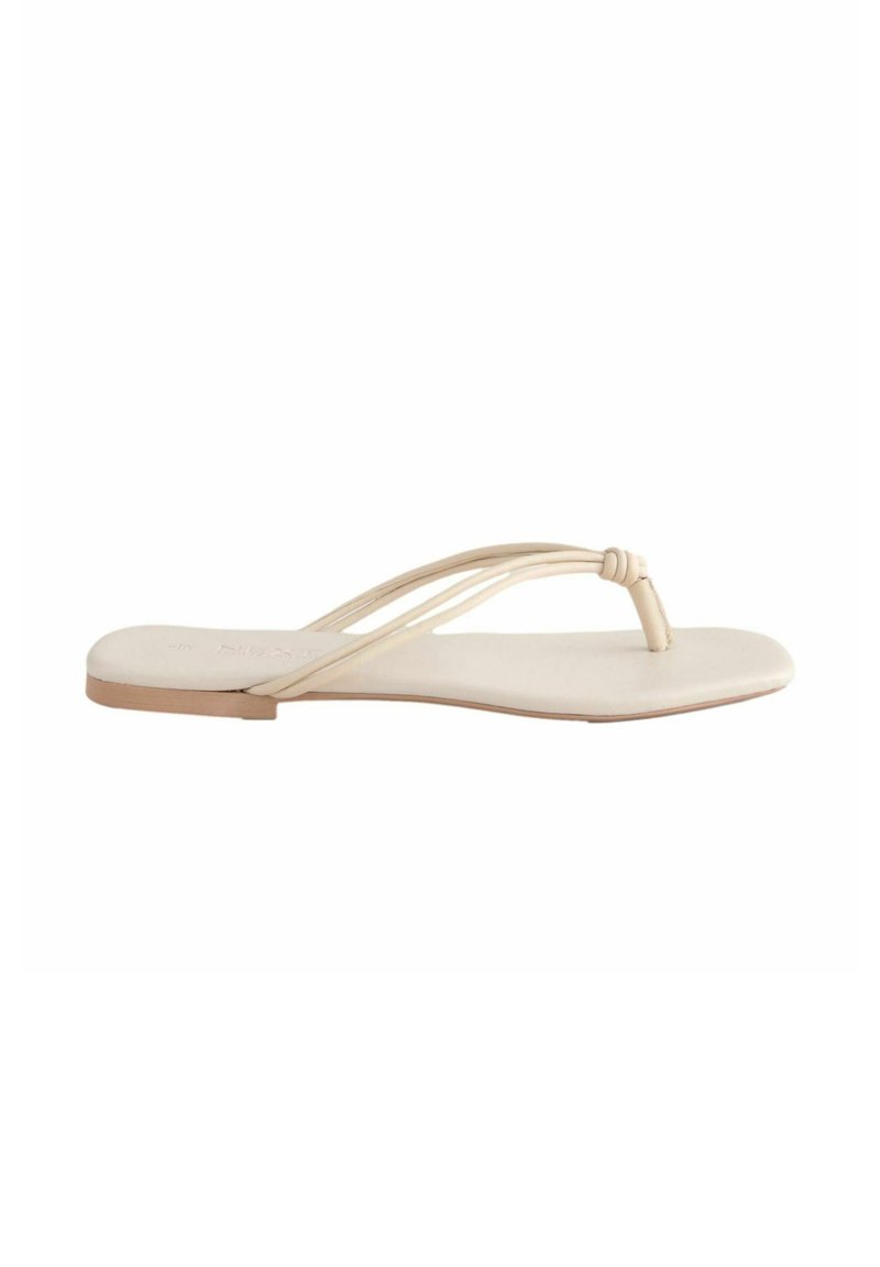 Platt tåsandaler i ljusbeige läder, med två tunna remmar och en mjuk innersula med en minimalistisk design.