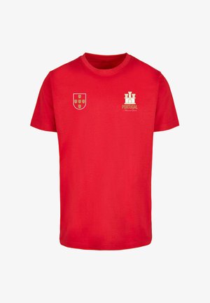 Červené bavlněné tričko s bílým a zlatým znakem a grafikou hradu, s nápisem "PORTUGAL" na přední straně. Krátké rukávy.