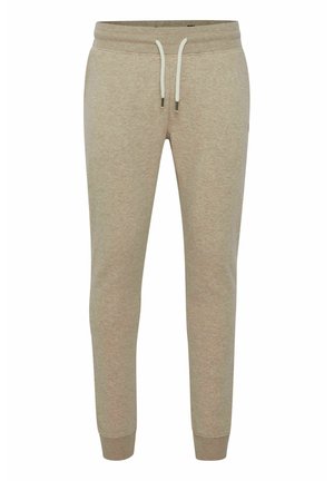Beige joggers van zacht materiaal, met een trekkoord in de taille, geknuffelde enkels en een gladde, gestructureerde uitstraling.