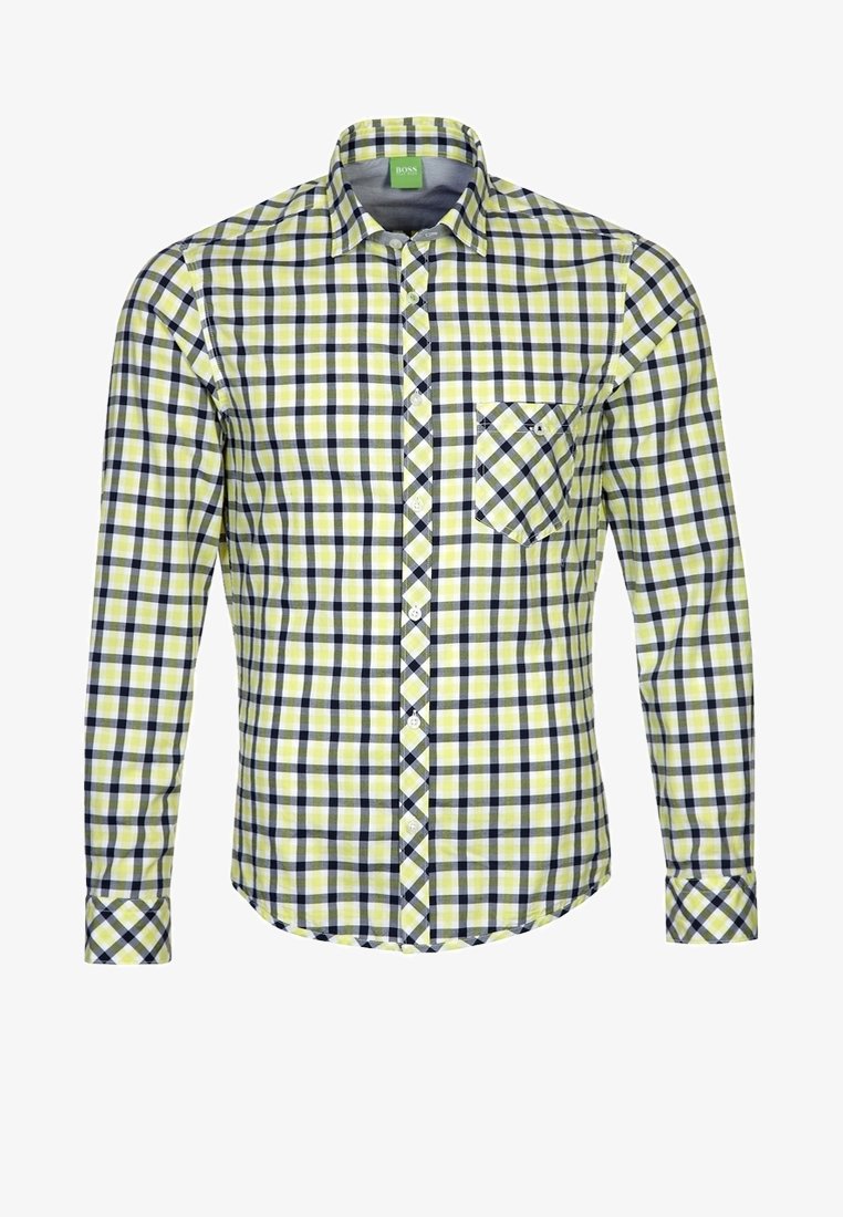 Chemise à manches longues boutonnée avec motif à carreaux jaune, blanc et noir et une poche poitrine sur fond blanc.